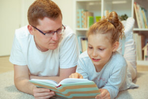 Father teaching daughter how to read